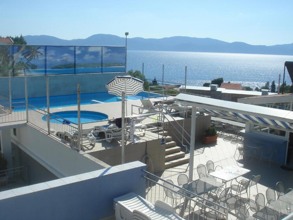a view of a swimming pool on a building next to the water at Aparthotel Pecic in Gradac