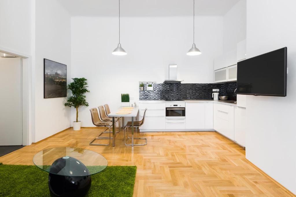 una cocina con armarios blancos y una mesa con sillas. en Apartment Jindrisska, en Praga