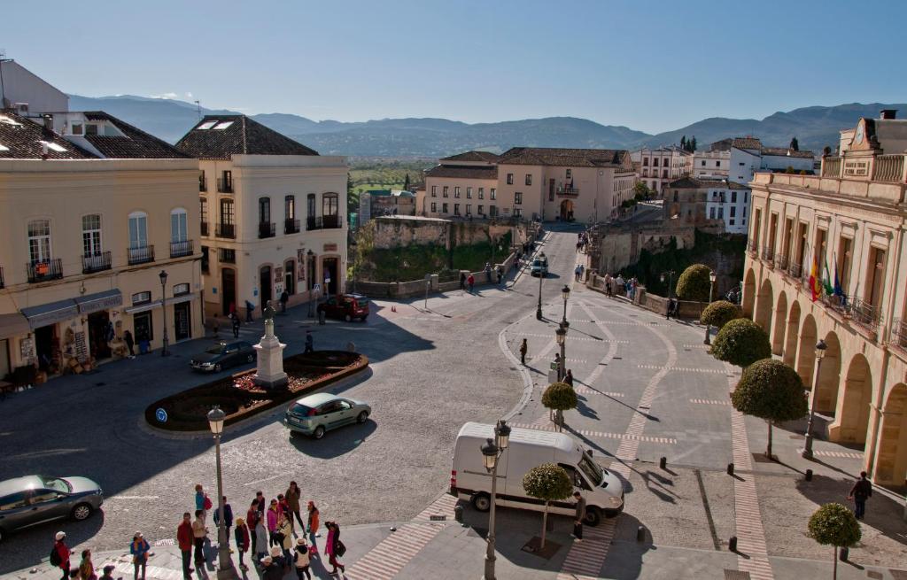 a group of people walking down a street in a city at Apartamentos Rondacentro in Ronda