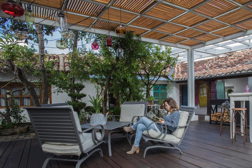 a woman sitting at a table on a patio at Mexicanos 10 CasaVieja in San Cristóbal de Las Casas