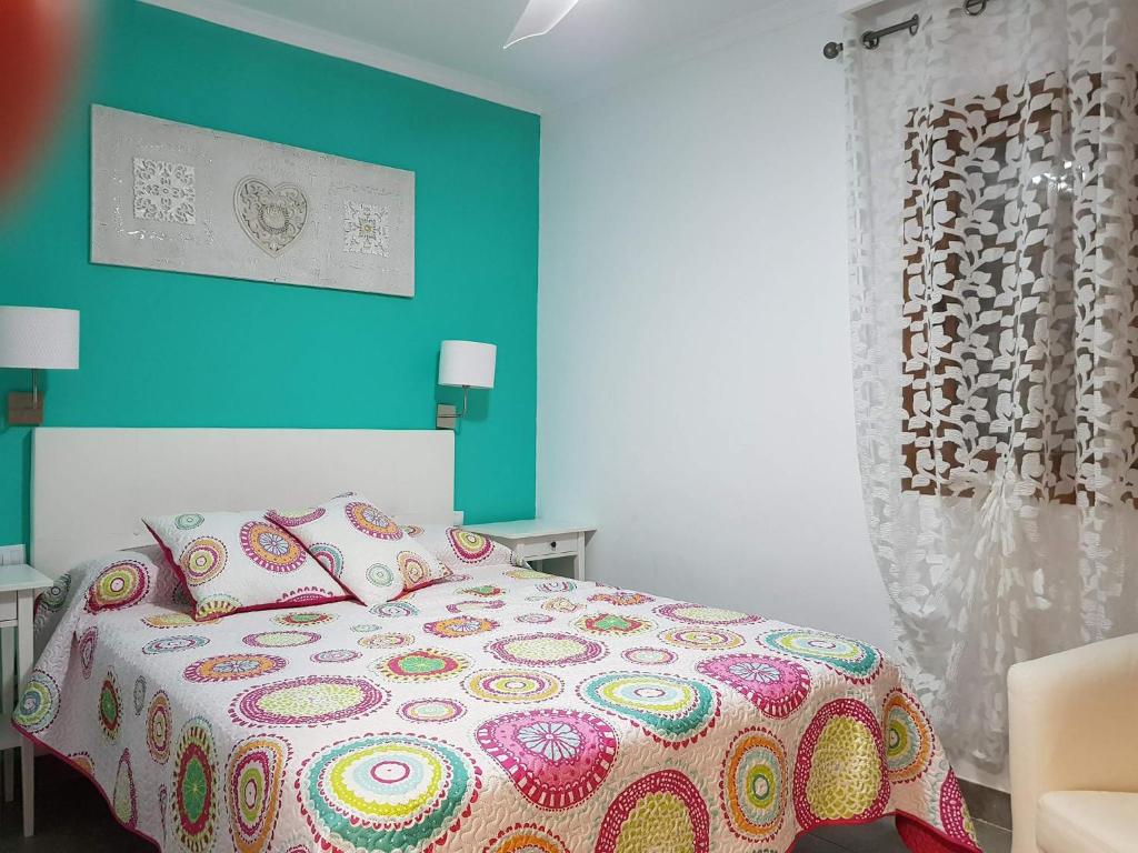 1 dormitorio con cama y pared azul en Bungalow Luisy, en Maspalomas