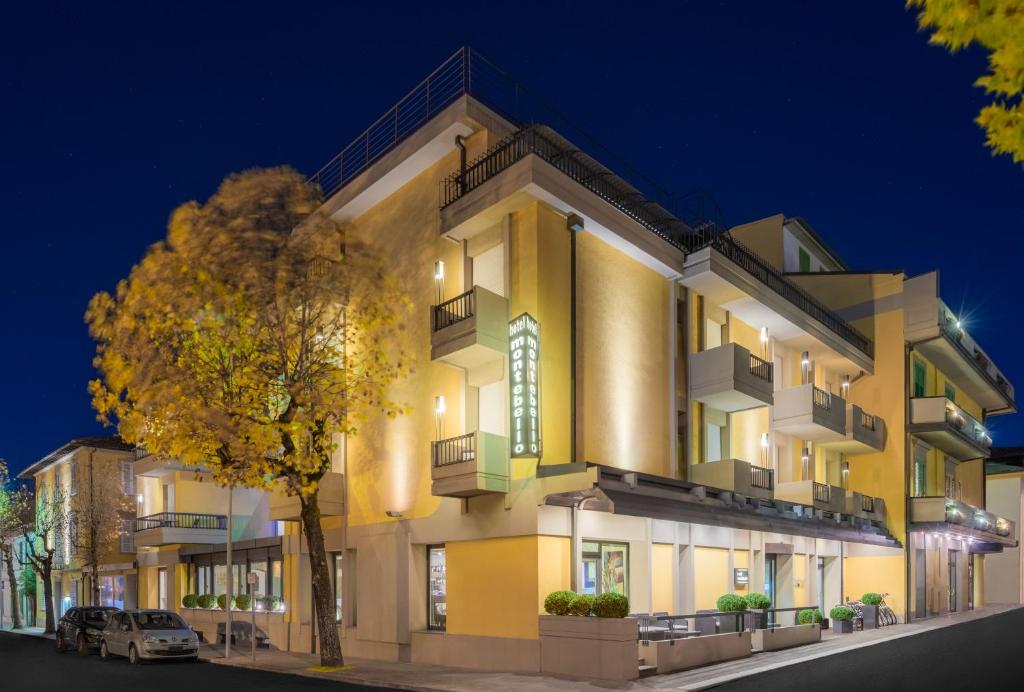 un edificio con un árbol delante de él en Hotel Montebello, en Montecatini Terme