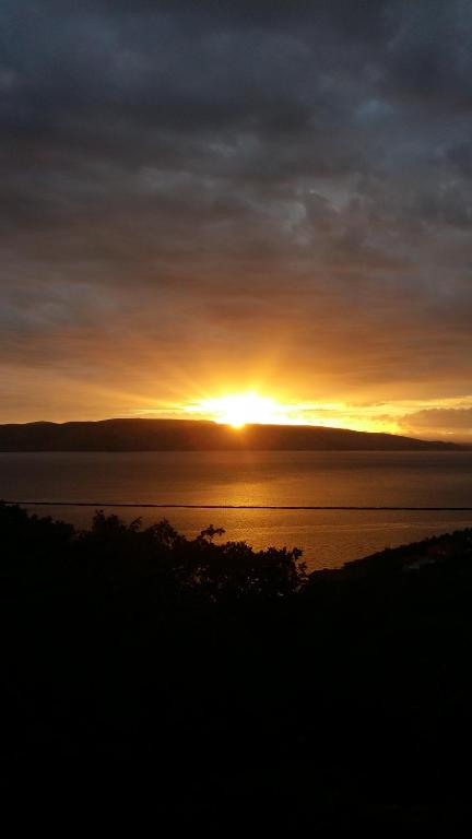 a sunset over a body of water with the sun setting at Dalibor in Senj