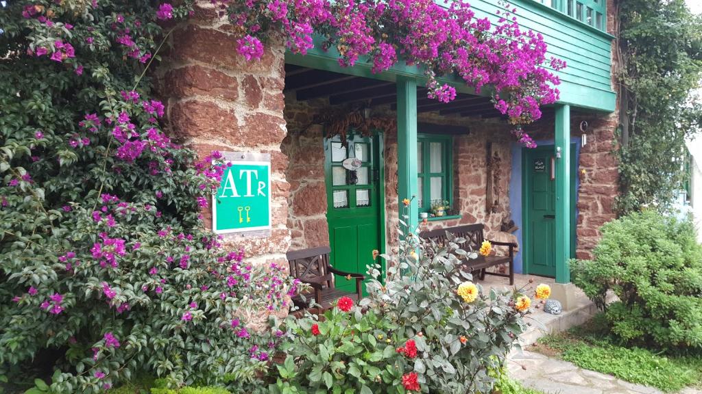 una casa verde con flores delante en Apartamentos Villar, en Villar