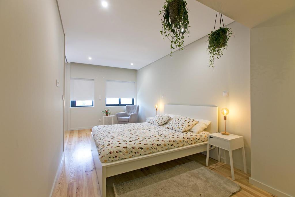1 dormitorio blanco con 1 cama y 1 silla en Porto Nascente, en Oporto
