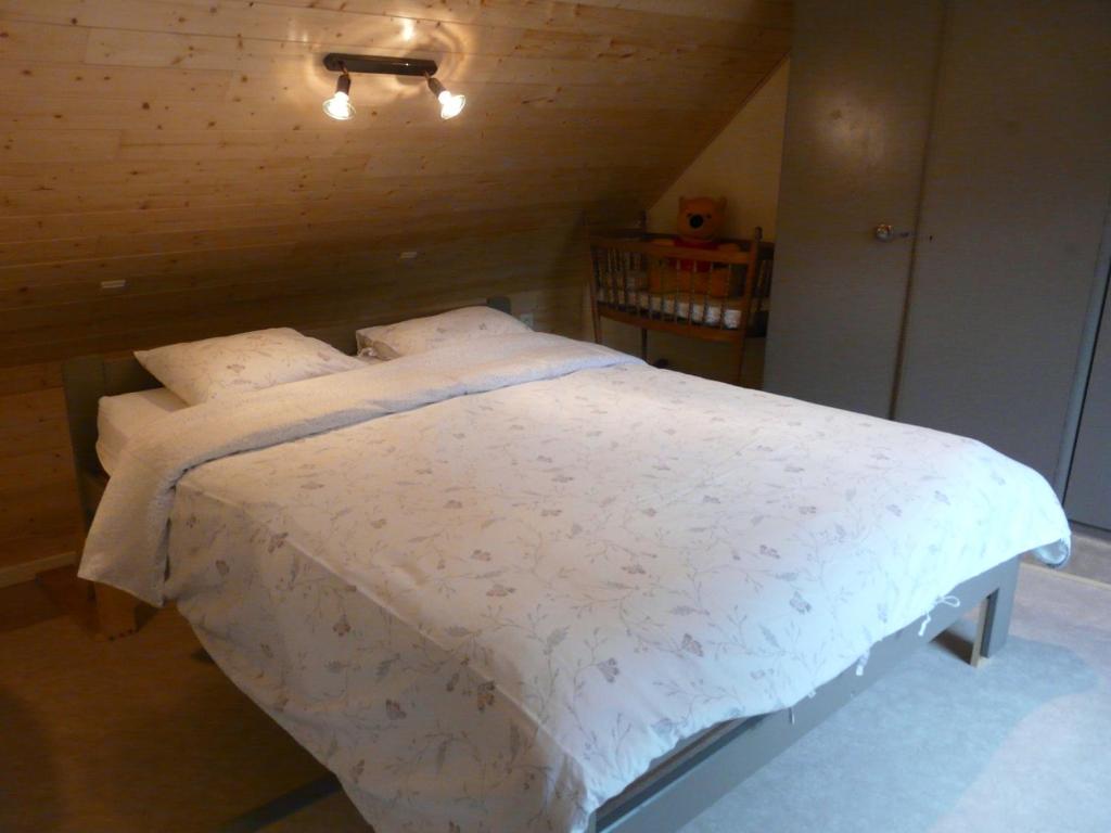 a bedroom with a bed with white sheets and pillows at La Quitapenas in Ronse