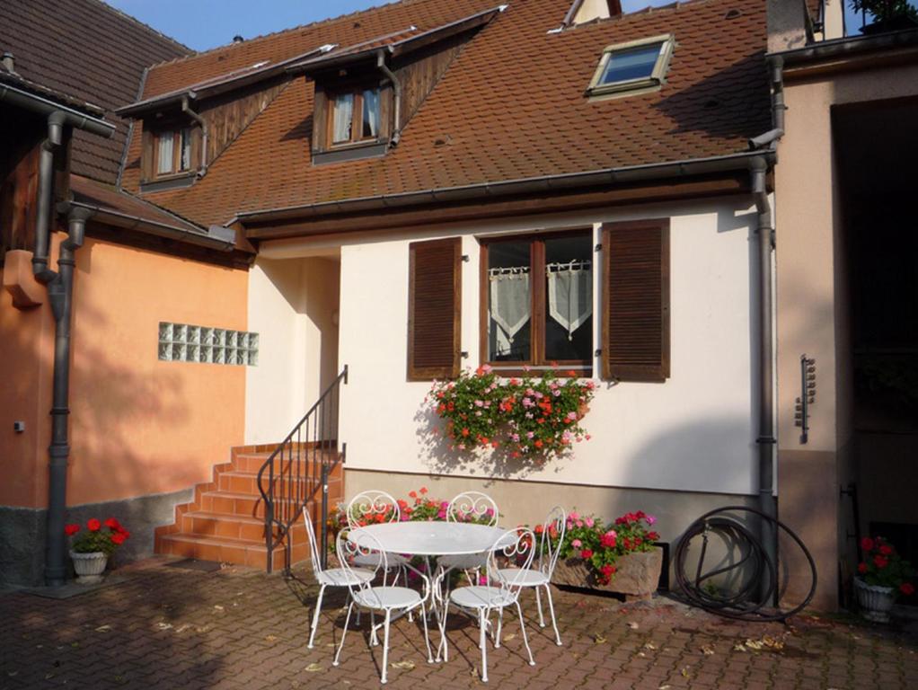 une table et des chaises devant une maison dans l'établissement Gîte Sonnenberg, à Ammerschwihr