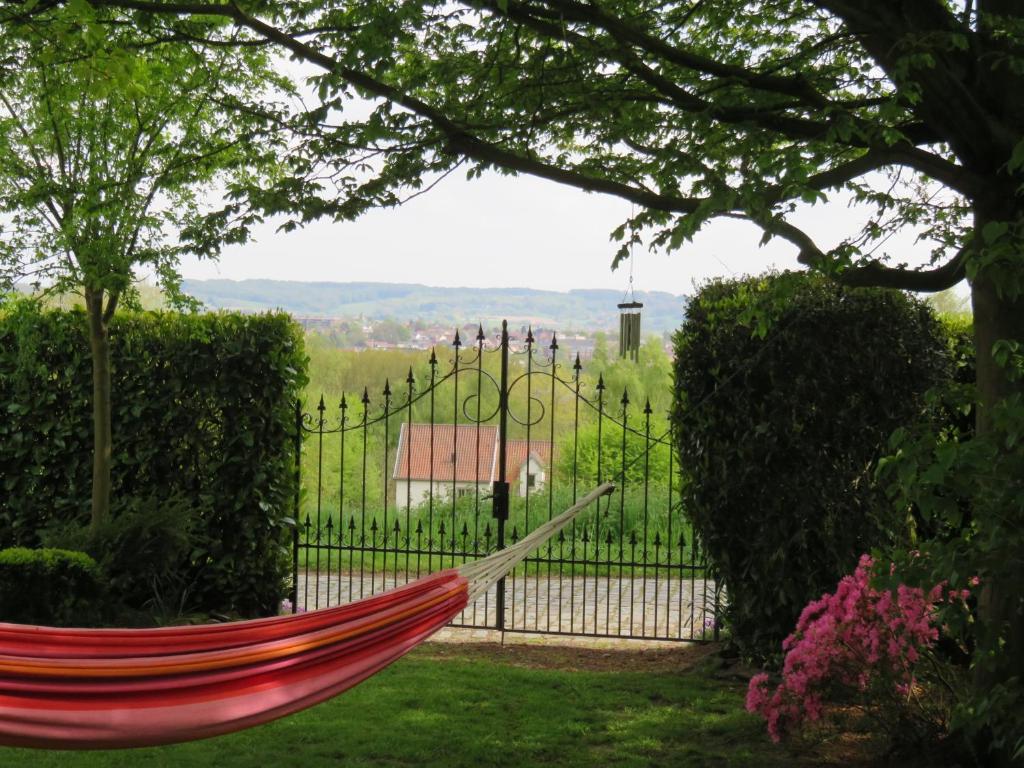a hammock in a garden with a fence at La Quitapenas in Ronse
