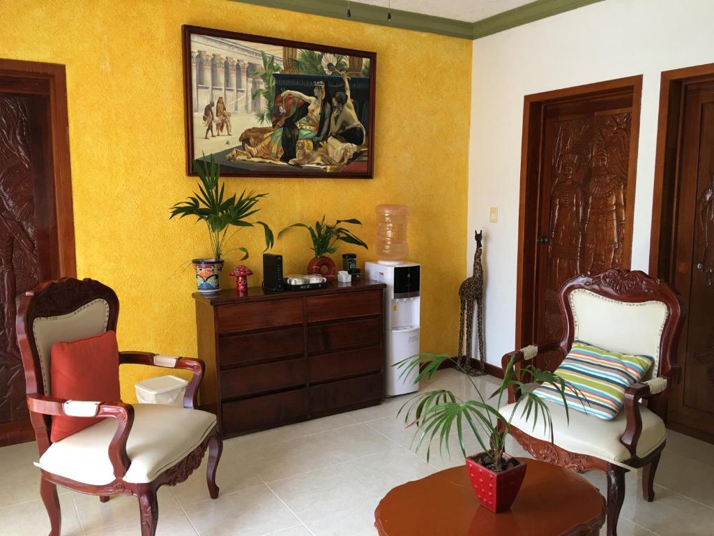 una sala de estar con 2 sillas y una pintura en la pared en Departamentos K&B en Playa del Carmen