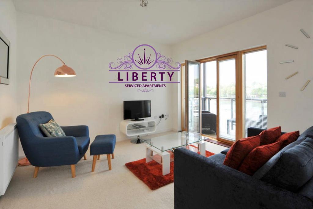 a living room with two blue chairs and a glass table at Liberty Marina in Portishead