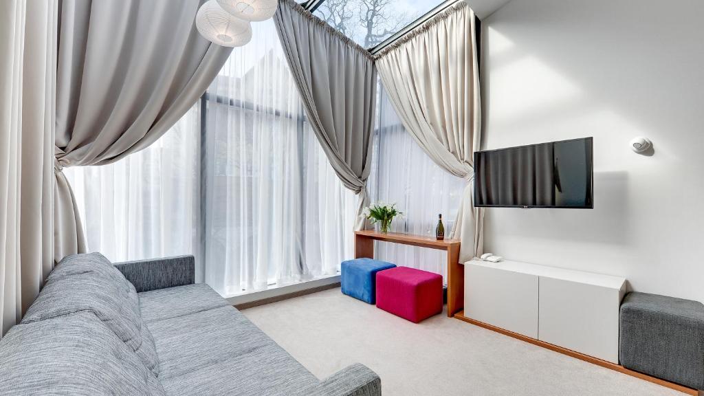 a living room with a couch and a tv at Villa 21 by Victus in Sopot