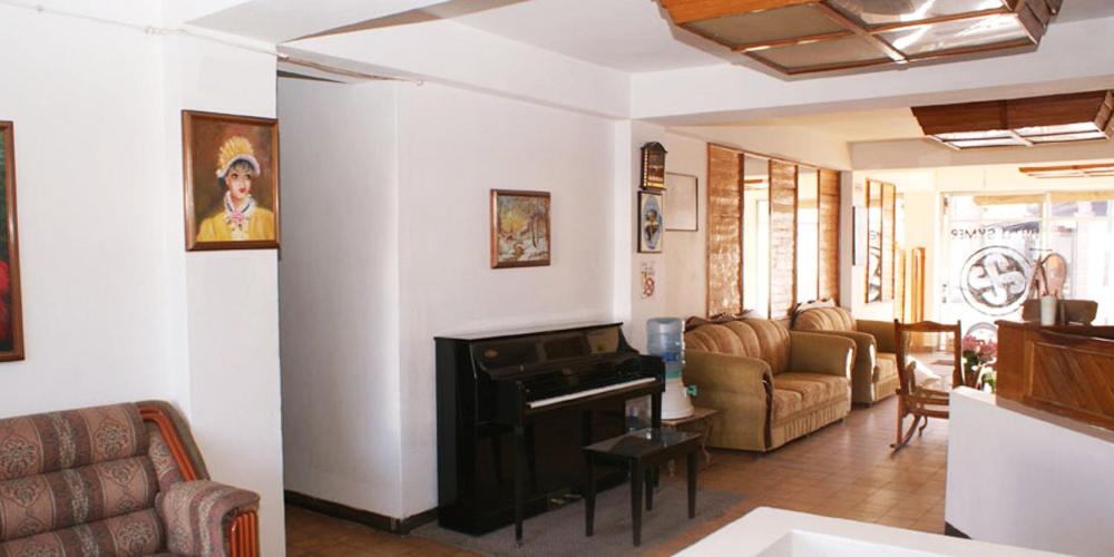 a living room with a couch and a piano at Hotel Symer in Chignahuapan