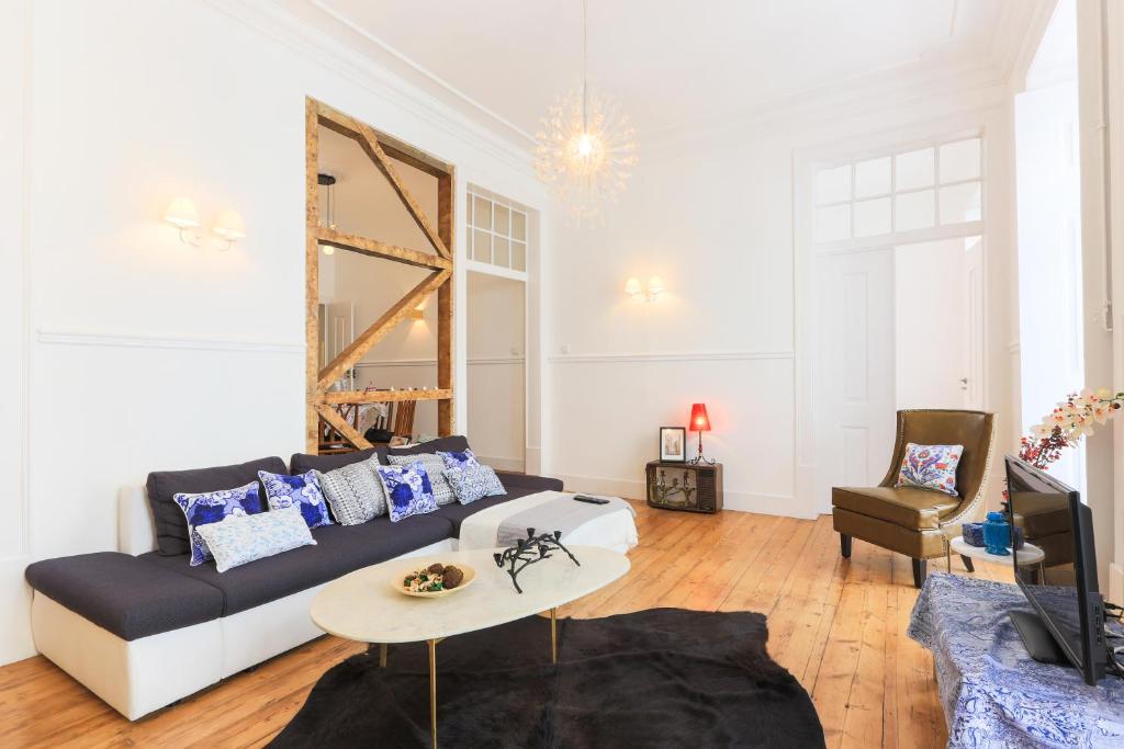 Una sala de estar con un sofá y un espejo. en Lisbon Secret & Charming Baixa 4 bedroom apartment, en Lisboa