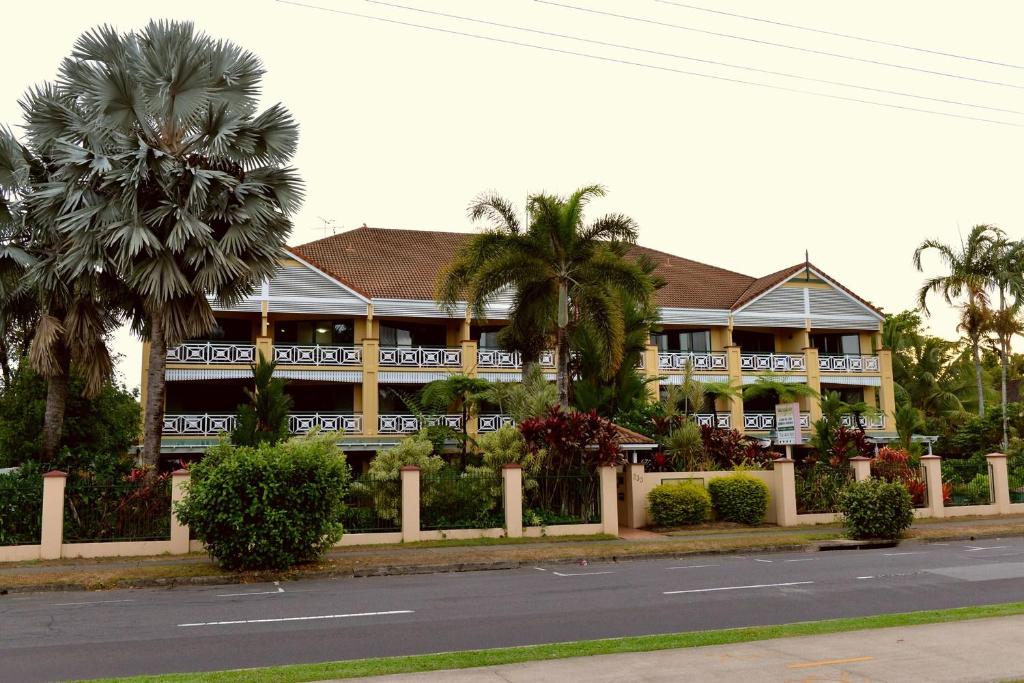 a large building with palm trees in front of a street at Waterfront Terraces in Cairns
