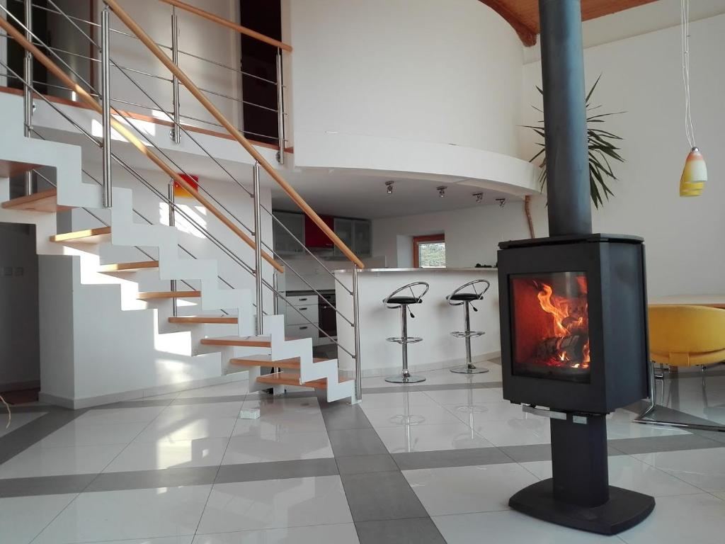 a fireplace in the middle of a room with stairs at U Lojzika in Pulkov
