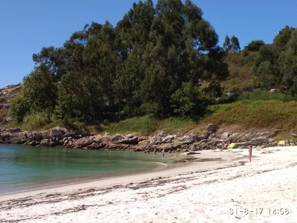 a beach with a group of people in the water at Eira do vento in Cangas de Morrazo