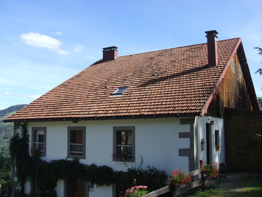 uma casa branca com um telhado castanho em La Ferme du Vieux Sapin em La Bresse