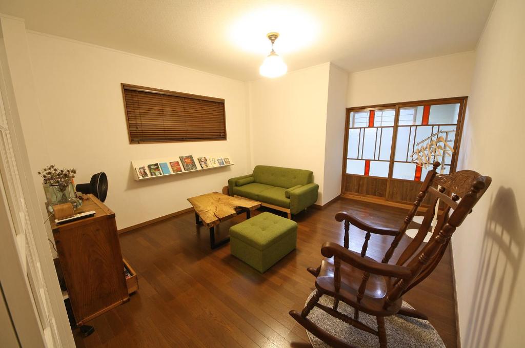 uma sala de estar com uma cadeira verde e um sofá em sumica apartments em Nikko
