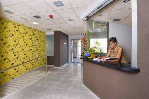 a woman sitting at a counter in an office at Llagotel in La Llagosta