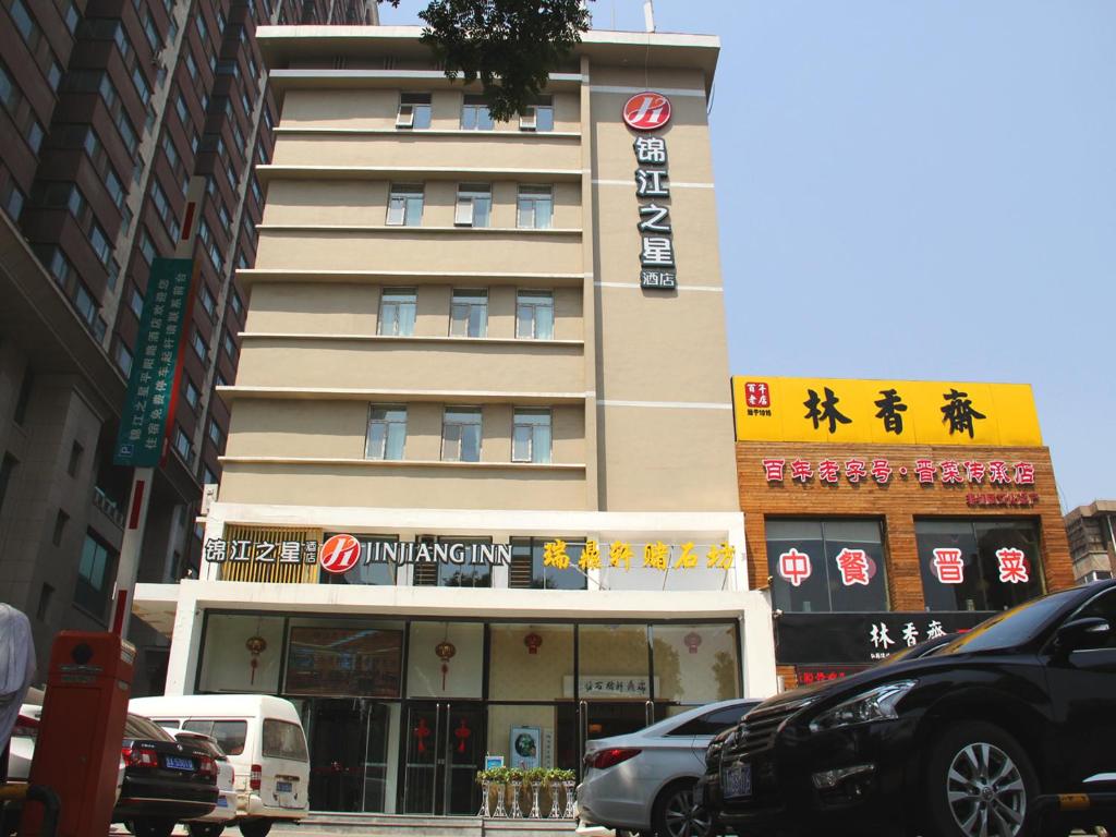a tall building with asian writing on it on a city street at JinJiang Inn Pingyang Taiyuan Road Hotel in Taiyuan