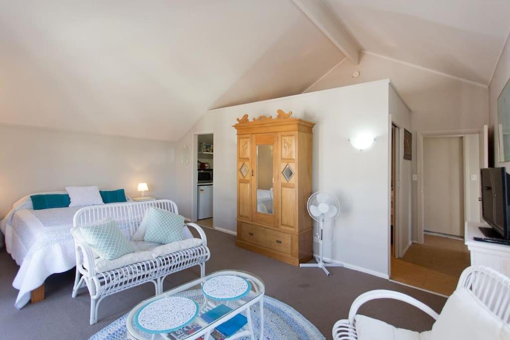 a bedroom with a bed and a living room at Fremantle Local Beach Studio in Fremantle