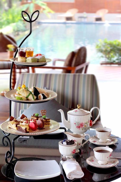 An afternoon-tea-style spread of pastries and drinks beside the pool.