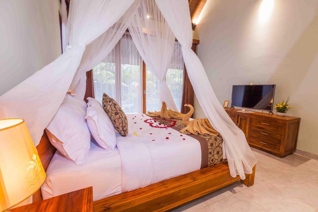 a bedroom with a bed with a mosquito net at Sweet Ginger Villa by Prasi in Ubud
