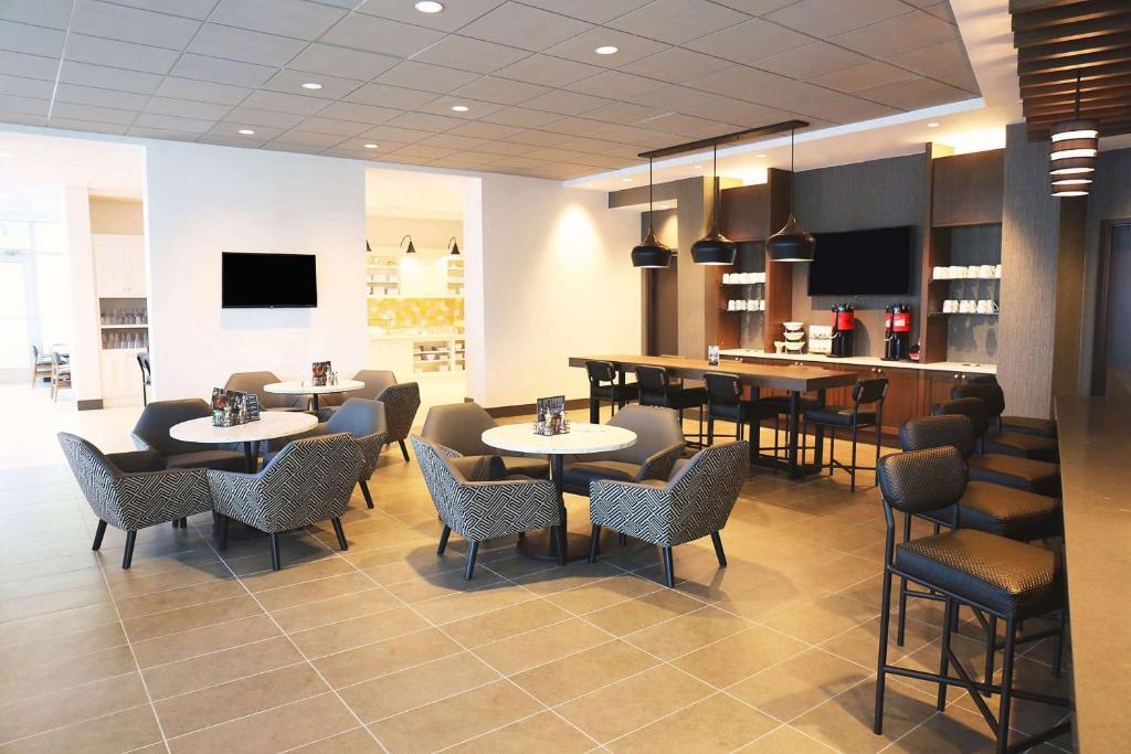 a restaurant with tables and chairs and a bar at Hyatt Place Austin Airport in Austin