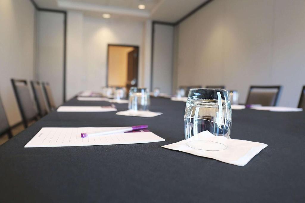 a long table with a pen and a glass at Hyatt Place Austin Airport in Austin