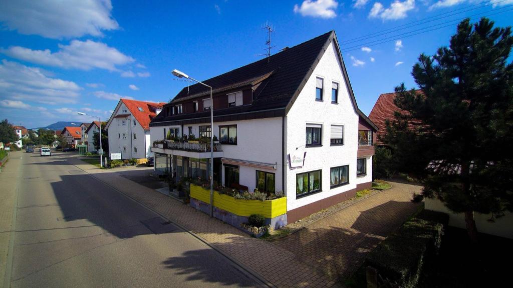 una casa blanca con techo negro en una calle en Hotel Rosengarten, en Schwäbisch Gmünd