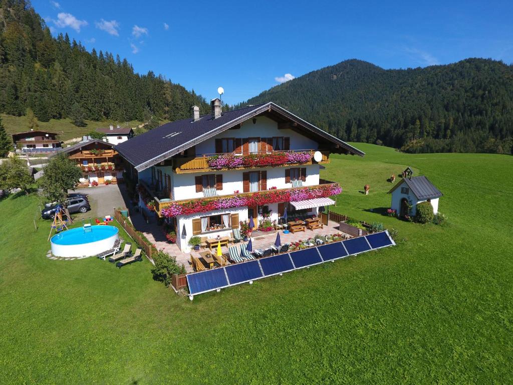 a large house with a swimming pool in a field at Bichlhof Riedenberg in Thiersee