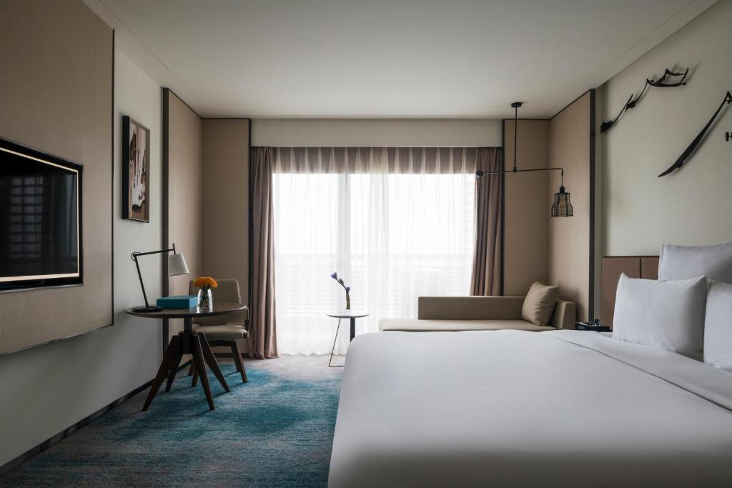 a hotel room with two beds and a window at Pullman Zhouzhuang in Kunshan