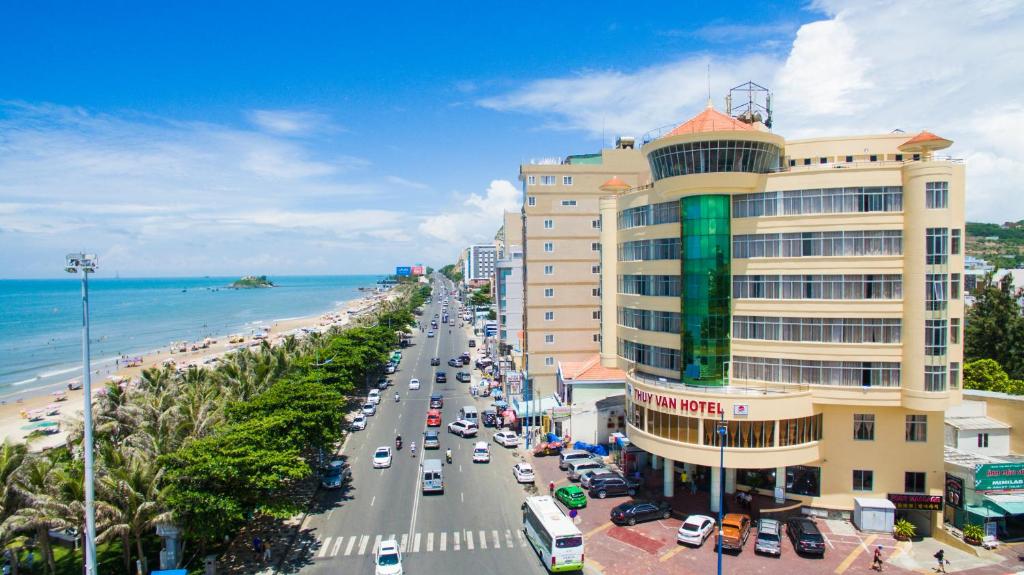 a busy street with a building and a beach at Thuy Van Hotel in Vung Tau