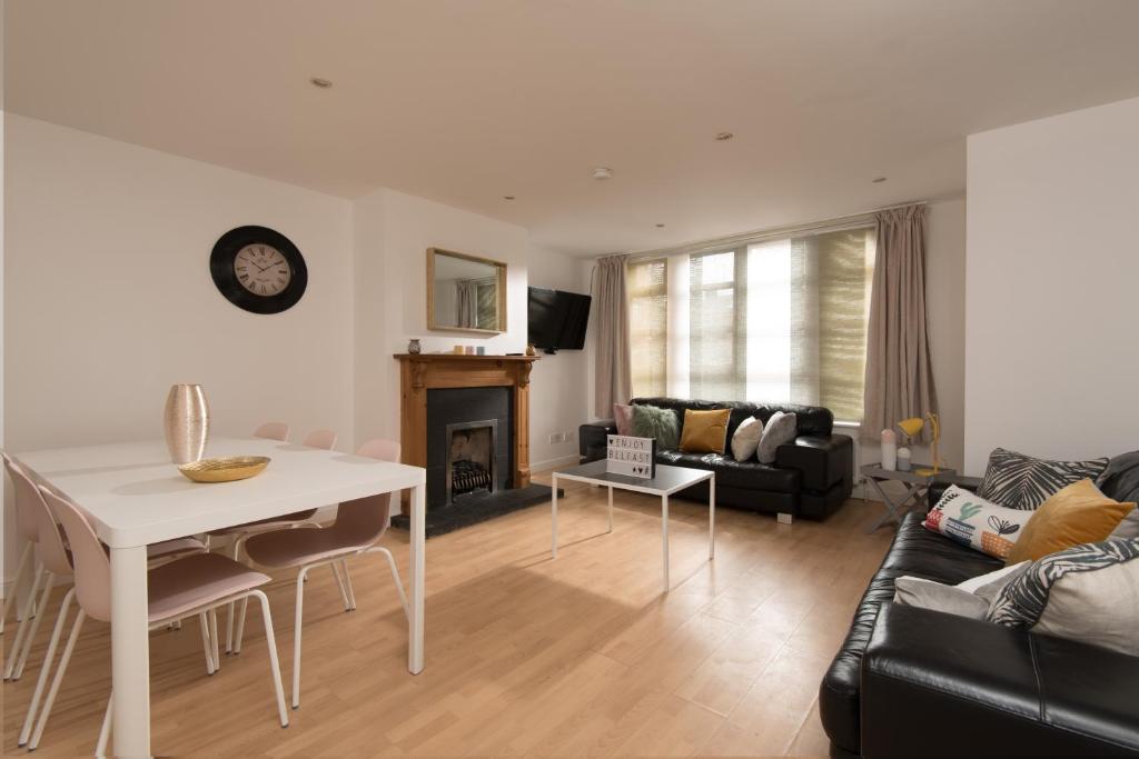 a living room with a white table and a couch at Big Fish Homes - The Cloisters in Belfast