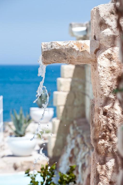 a stone cross with water coming out of it at Hotel Don Ferrante in Monopoli