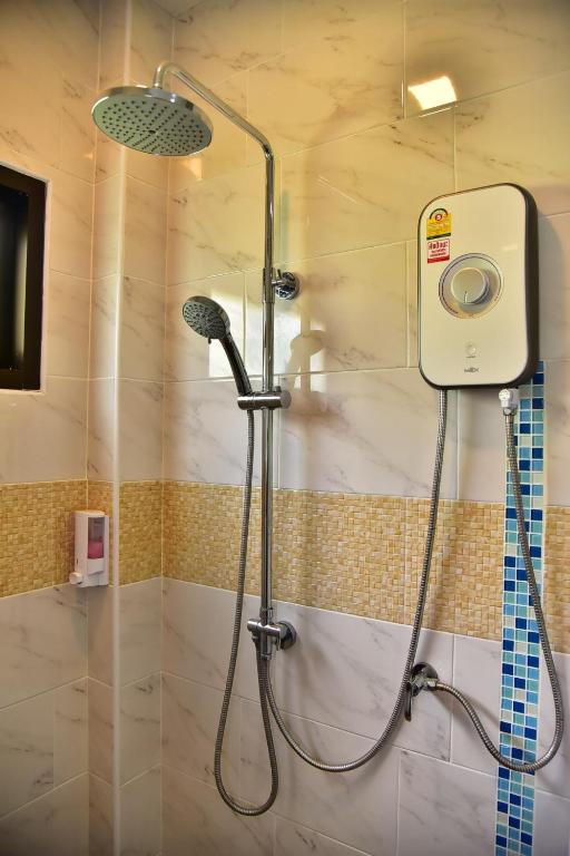una doccia con una porta in vetro in un bagno di The House at Pranburi a Pran Buri