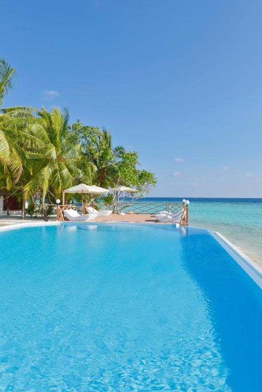 a large blue swimming pool next to the ocean at Thulhagiri Island Resort & Spa in North Male Atoll