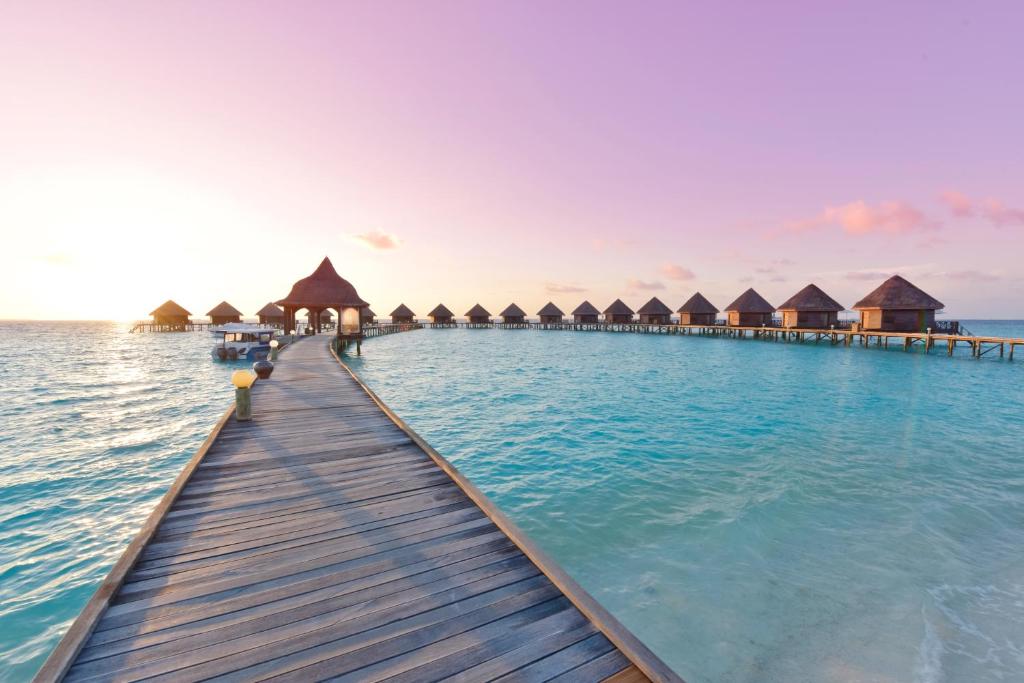 a dock in the water with overwater bungalows at Thulhagiri Island Resort & Spa in North Male Atoll