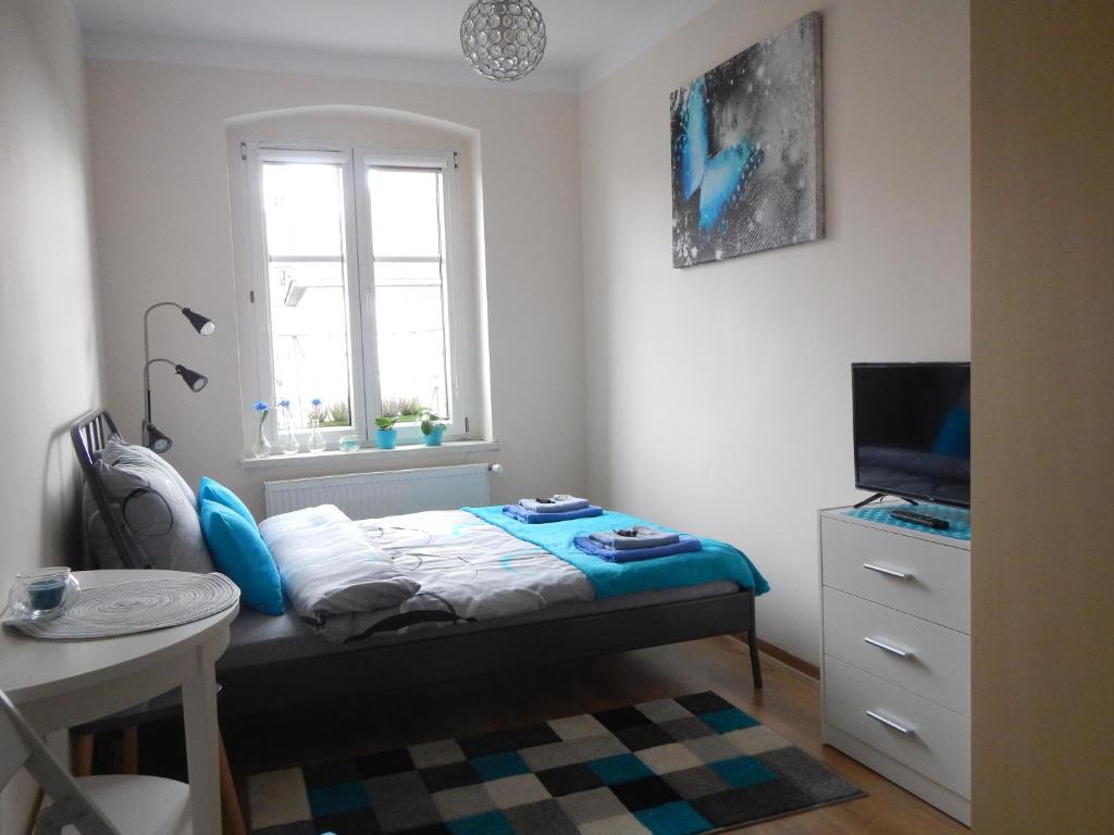 a small bedroom with a bed and a window at Traugutta apartment in Wrocław