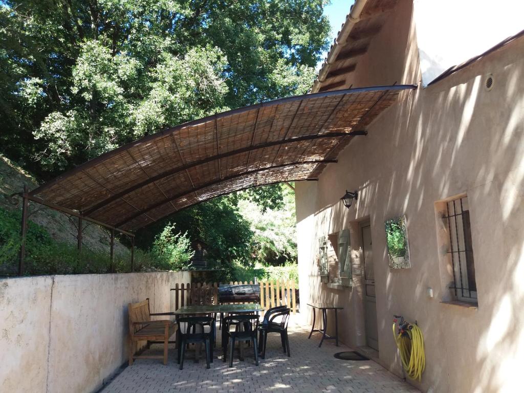 un patio avec une table et des chaises à côté d'un bâtiment dans l'établissement Holiday Home le cœur boisé, à Saint-Jeannet