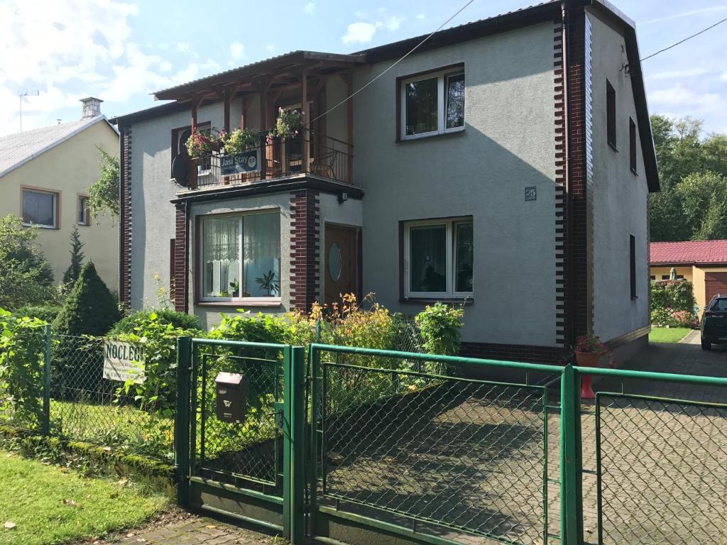 a house with a green fence in front of it at Jasi Stay in Augustów