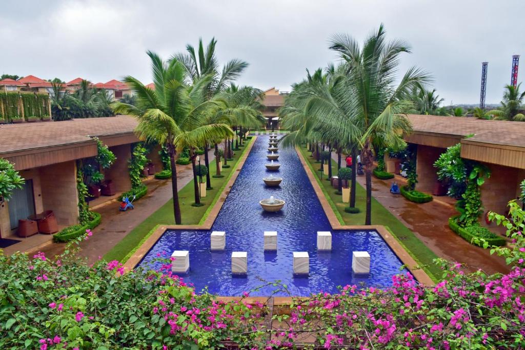 a canal in the courtyard of a resort with palm trees at Della Resorts in Lonavala