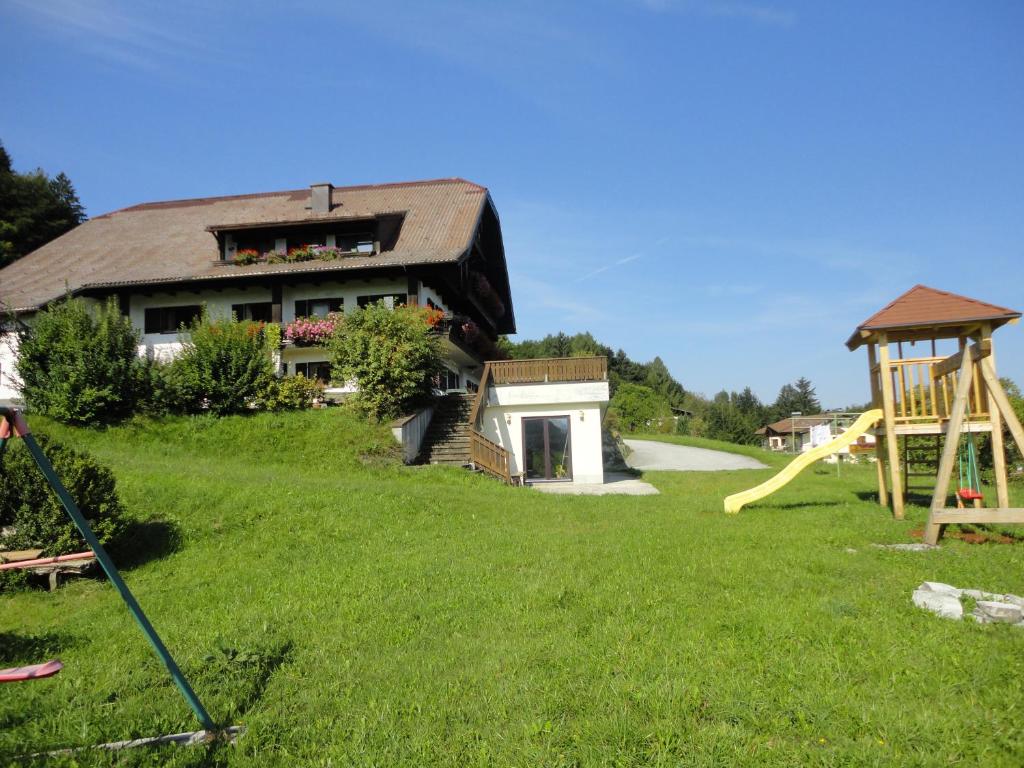 un cortile con una casa e un parco giochi di Bauernhof Strumegg a Hof bei Salzburg