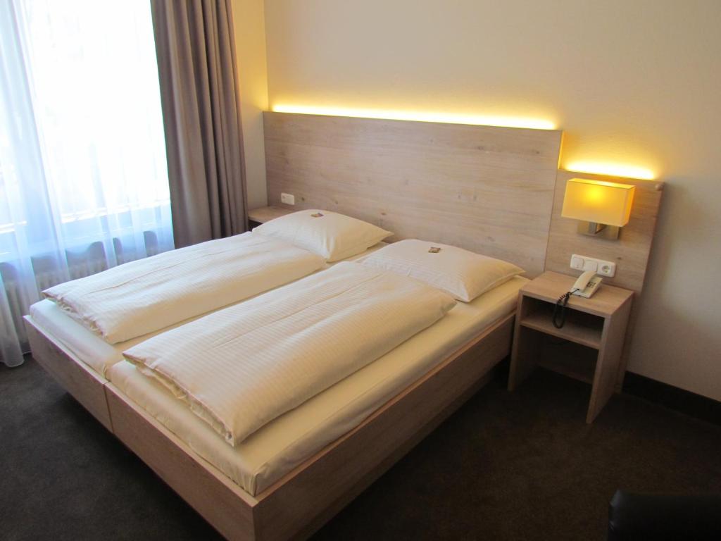 a bedroom with a large bed with a wooden headboard at Hotel Lutter in Munich