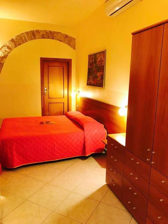 a bedroom with a red bed and a dresser at Corato room economy in Corato