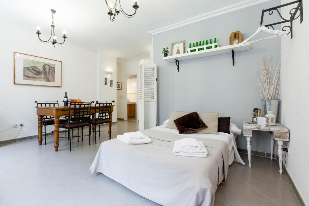 a white bedroom with a bed and a dining room at Los Ventanales Plaza Mayor in Madrid