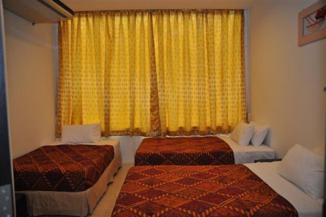 a hotel room with two beds and a window at Old Budget Hotel in George Town