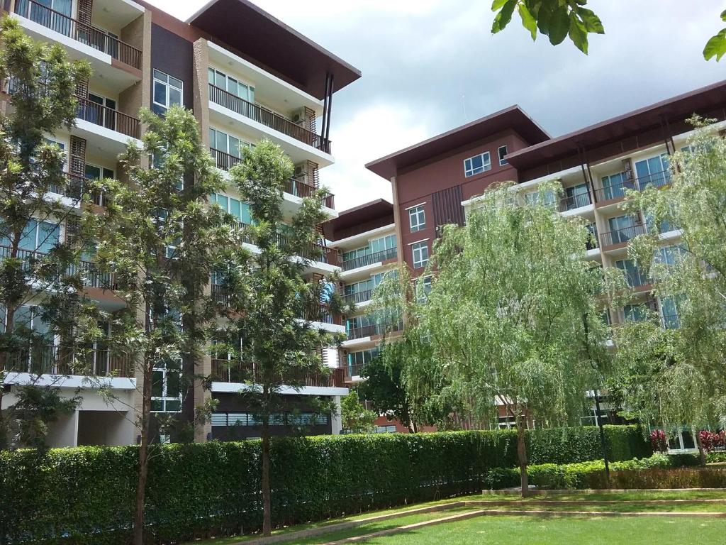 un immeuble d'appartements avec des arbres au premier plan dans l'établissement Baan Khao Yai, à Pak Chong