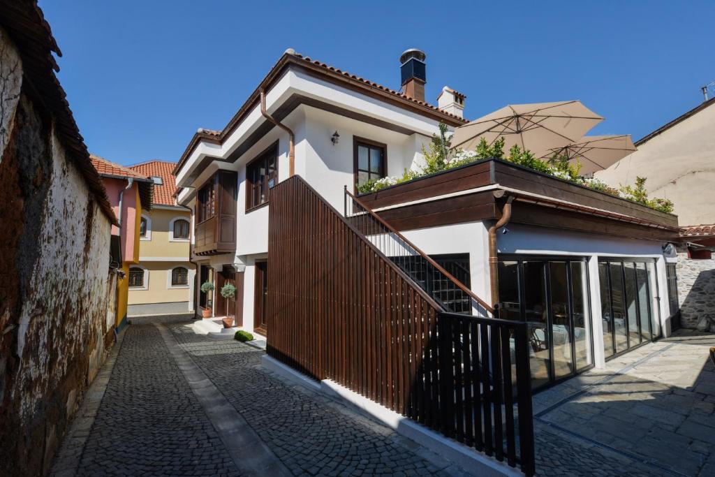 Ein weißes Haus mit einem schwarzen Zaun in einer Straße in der Unterkunft Hotel Tiffany in Prizren