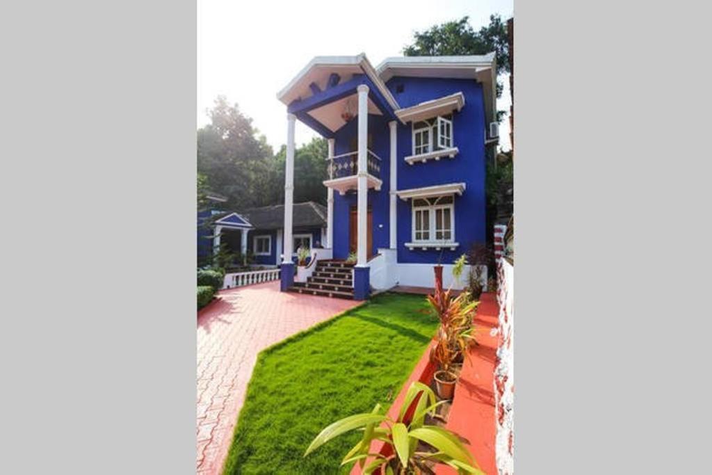 a blue house with a lawn in front of it at The Pereira's Goan Homestay Villa in Vasco Da Gama